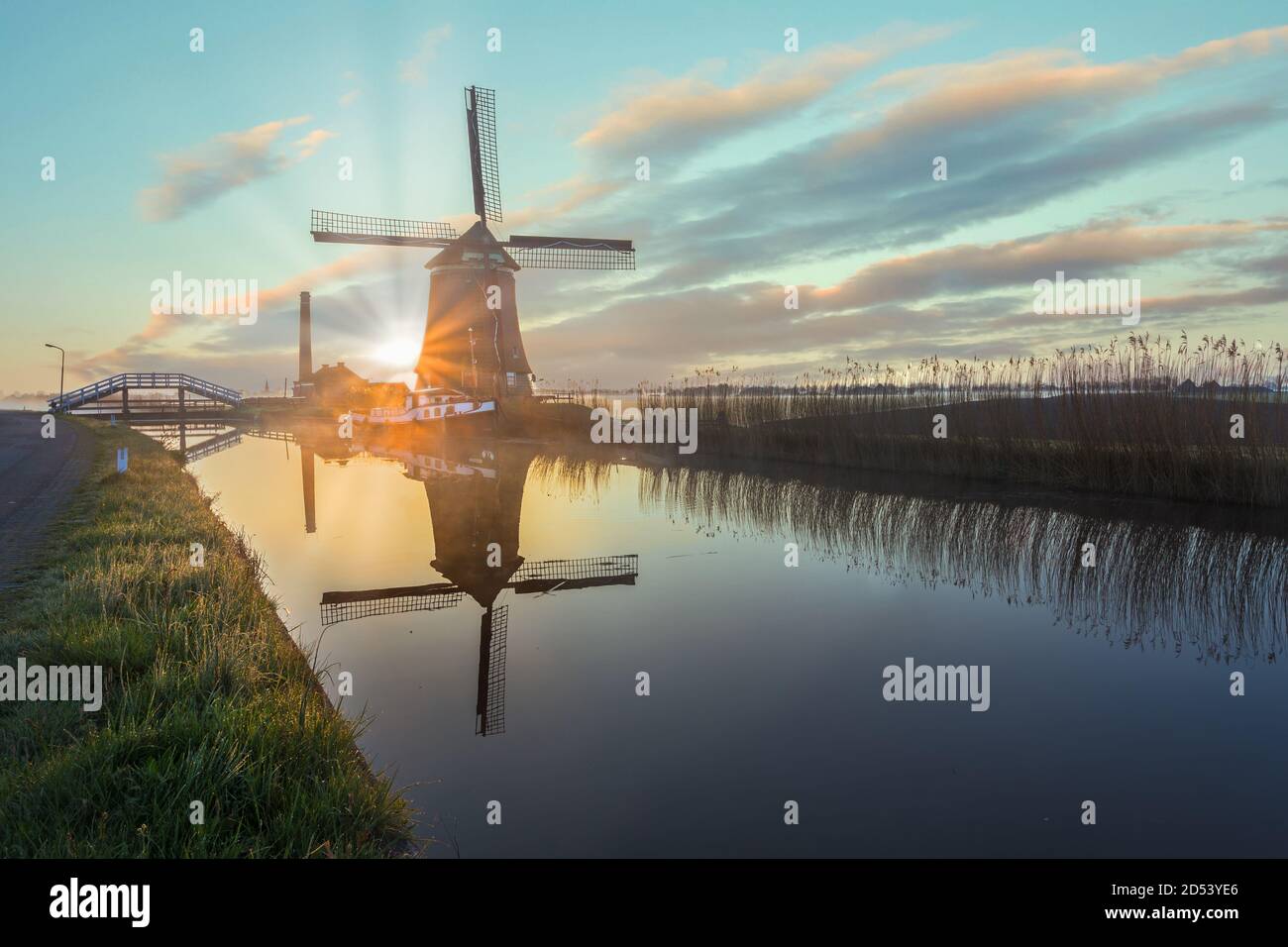 Il mulino a vento De Kaagmolen di fronte a un canale e barca, Olanda del Nord, Paesi Bassi Foto Stock