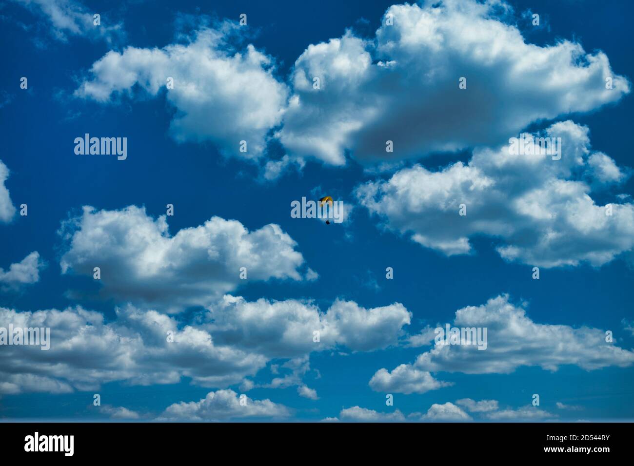 Inquadratura a basso angolo di un parapendio sotto un cielo blu nuvoloso a Limassol, Cipro Foto Stock