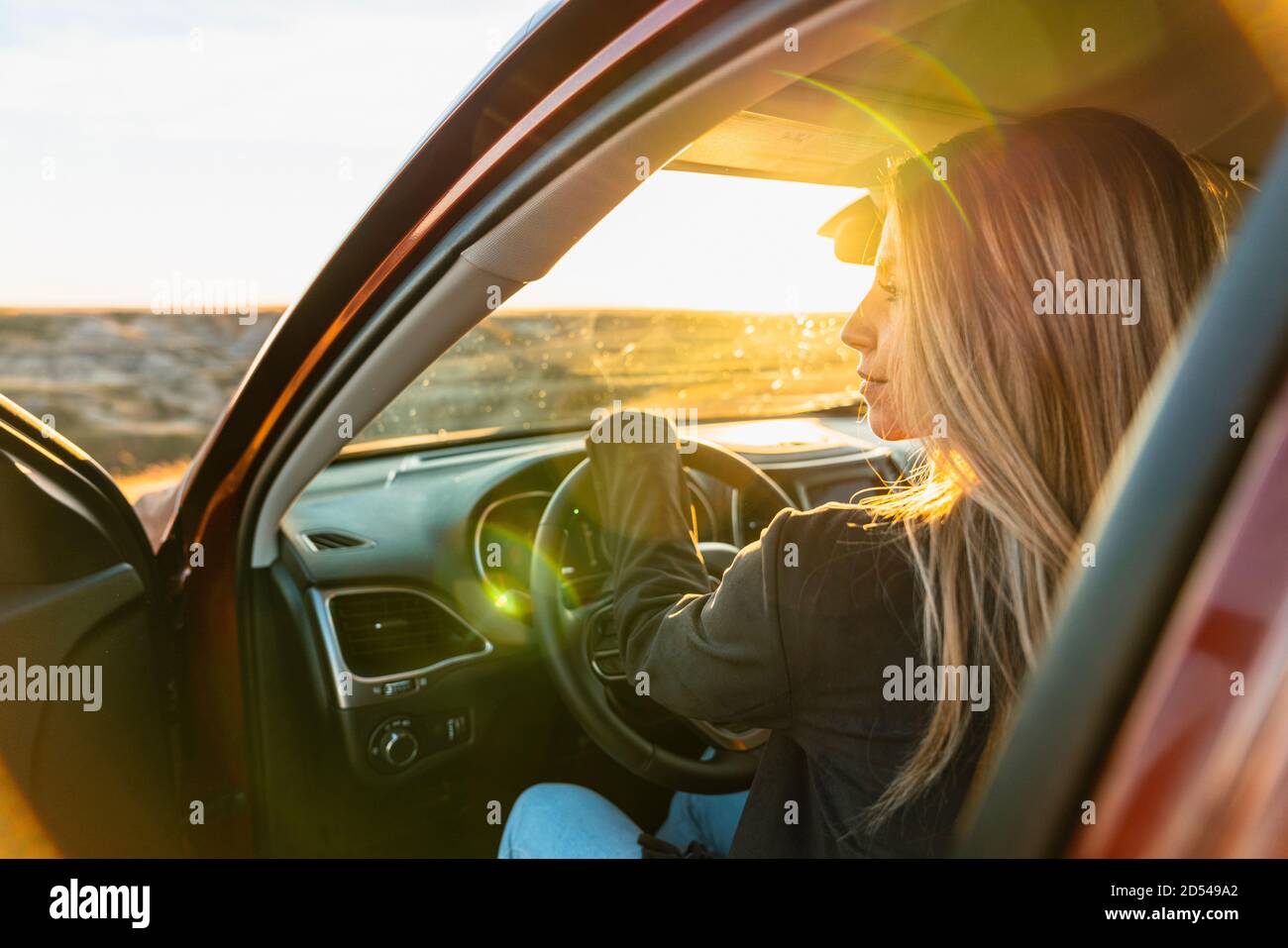 Donna che guida fuori strada per catturare il tramonto paese Foto Stock