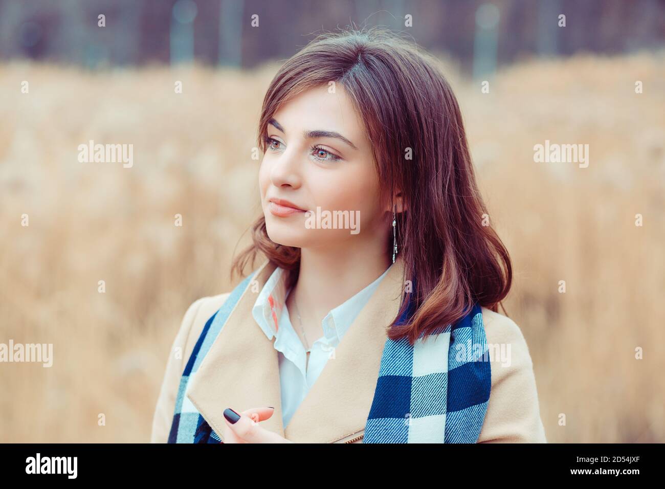 Bella Donna guardando al lato via pensando sorridente beige Cappotto in autunno all'aperto sfondo del parco Foto Stock