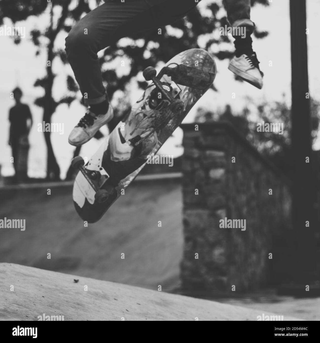 Immagine in scala di grigi di uno skateboarder che fa salti freestyle Foto Stock