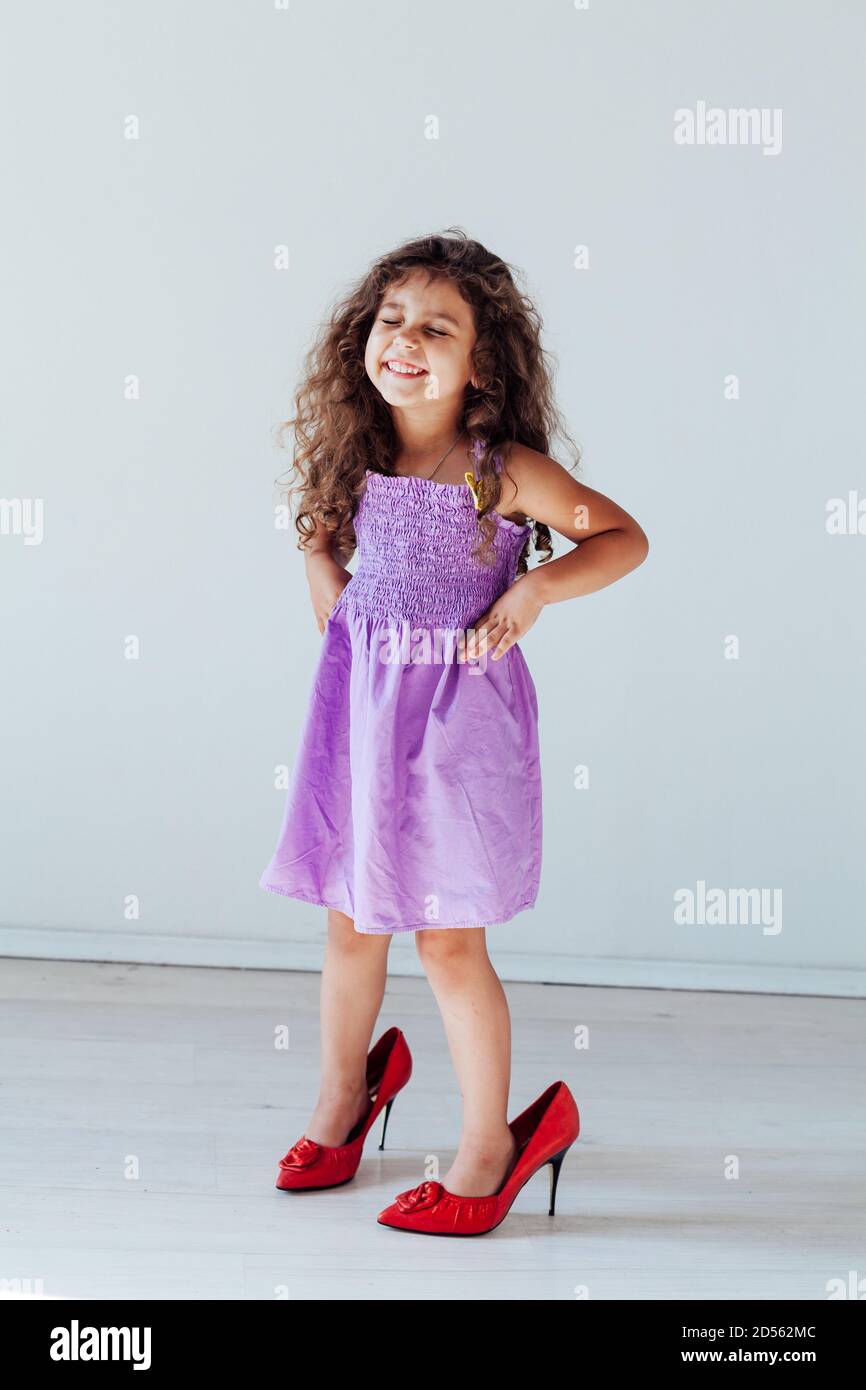 Bella ragazza piccola curly alla moda nelle scarpe della mamma Foto stock -  Alamy
