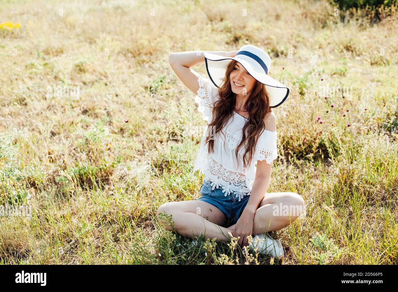 ritratto di una bella donna alla moda in un cappello con campi su un picnic in natura Foto Stock