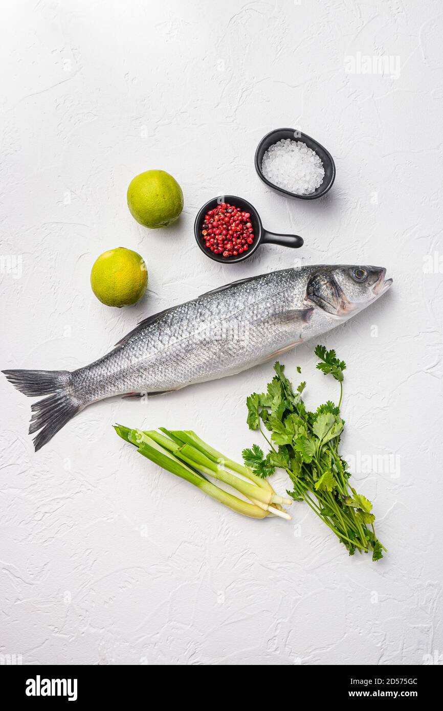Scottatura con spezie ed erbe ingredienti sulla tagliere sopra vista dall'alto sfondo con texture bianche Foto Stock