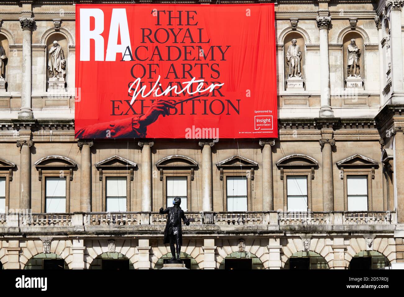 Londra, Regno Unito. - 5 Ott 2020: Una statua mascherata di fronte ad un banner che pubblicizzava la tradizionale mostra estiva della Royal Academy, ritardata fino ad ottobre a causa della pandemia del coronavirus. Foto Stock