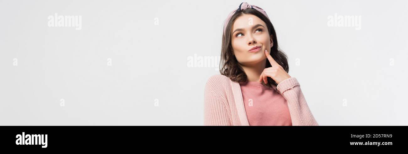 immagine orizzontale di una donna pensiva con archetto che tocca il viso e. guardando in alto isolato su bianco Foto Stock