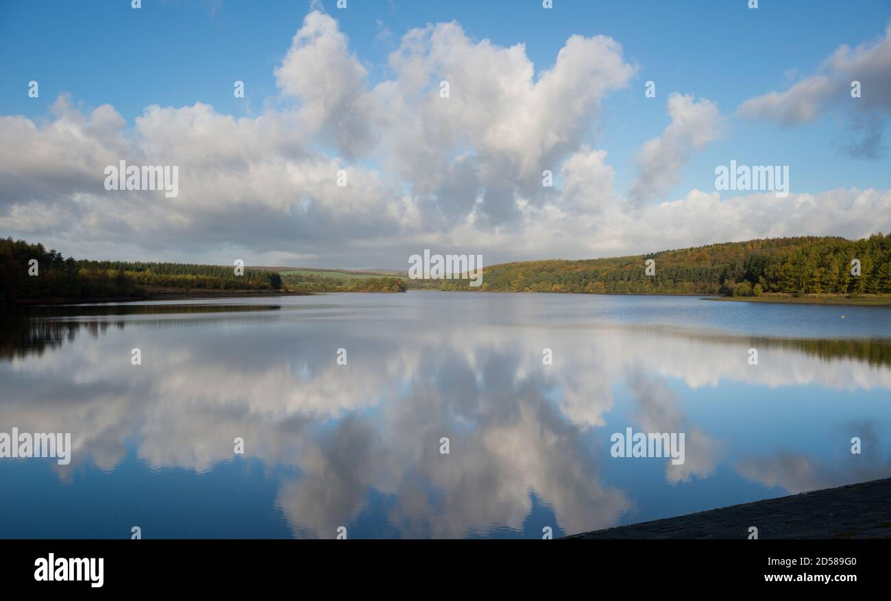 Le nuvole di Cumulus si riflettevano nelle acque ferme del bacino idrico di Fewston nella valle di Washburn, nello Yorkshire del Nord Foto Stock