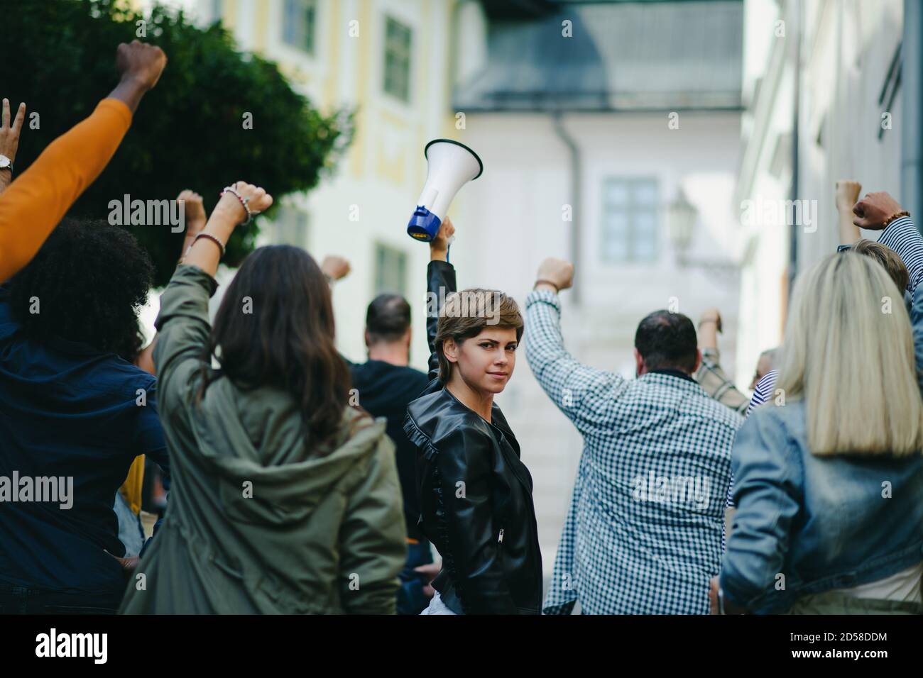 Ritratto di donna con megafono che protesta per le strade, sciopero e dimostrazione di concetto. Foto Stock