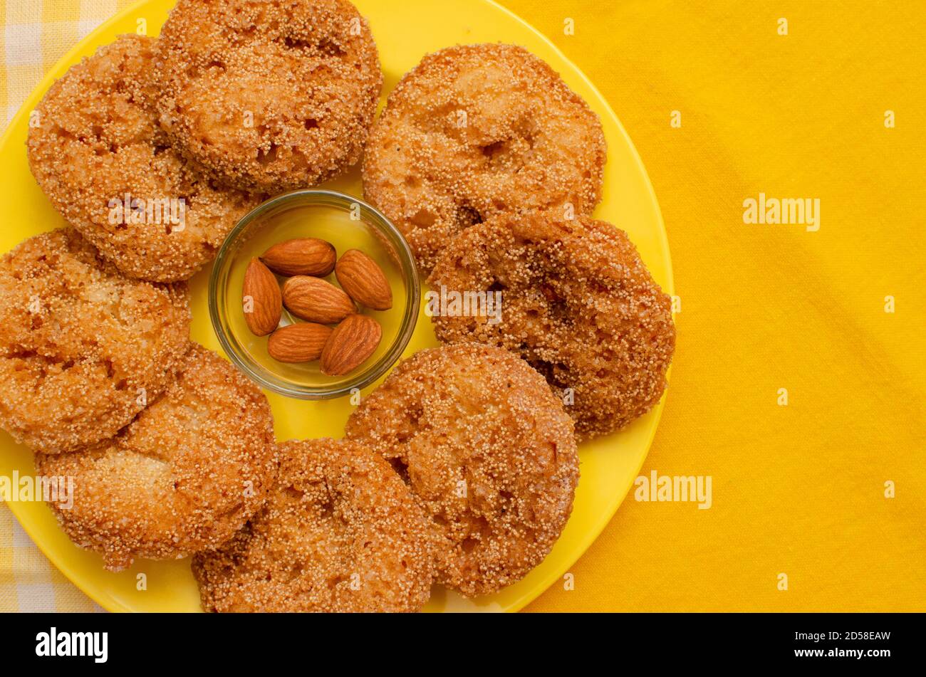Anarasa una tipica prelibatezza maharashtriana disposta in un piatto di colore giallo. Spuntino indiano tipo pasticceria comunemente associato con il festival Diwali Foto Stock