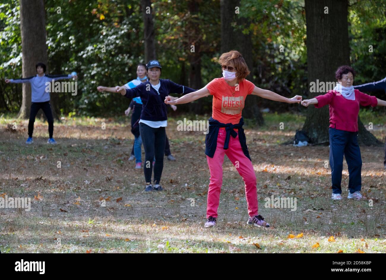 Donne asiatiche americane in una lezione di danza in un parco a Flushing, Queens, New York City. Alcuni sono mascherati, alcuni no, Foto Stock