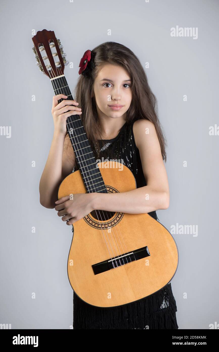 Ritratto di una ragazza che tiene una chitarra acustica Foto Stock