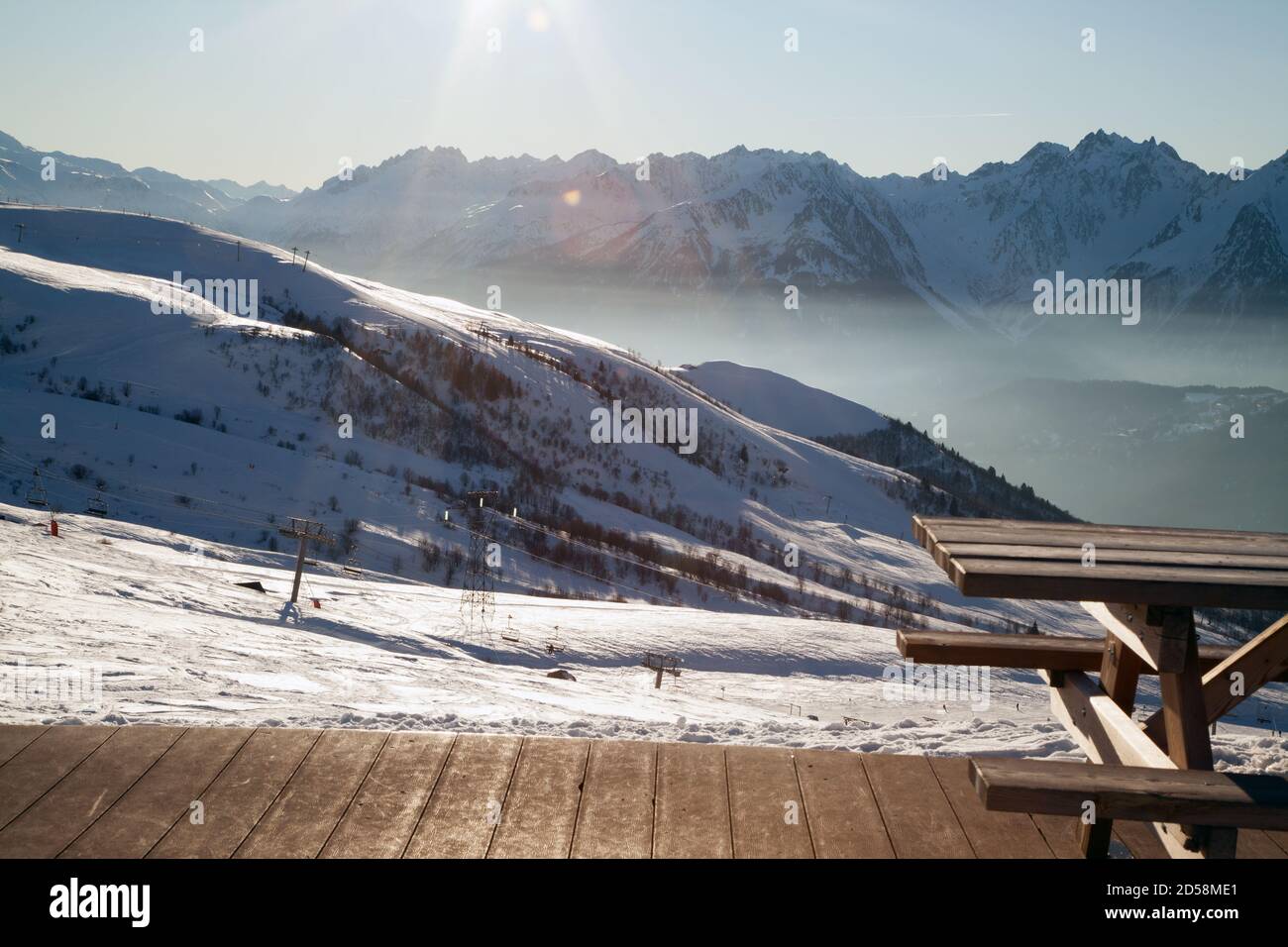 Saint-François-Longchamp : altitudine giorno di sole con un tavolo di legno e pavimento sulla destra e seggiovia sullo sfondo. Maurienne Savoia Foto Stock