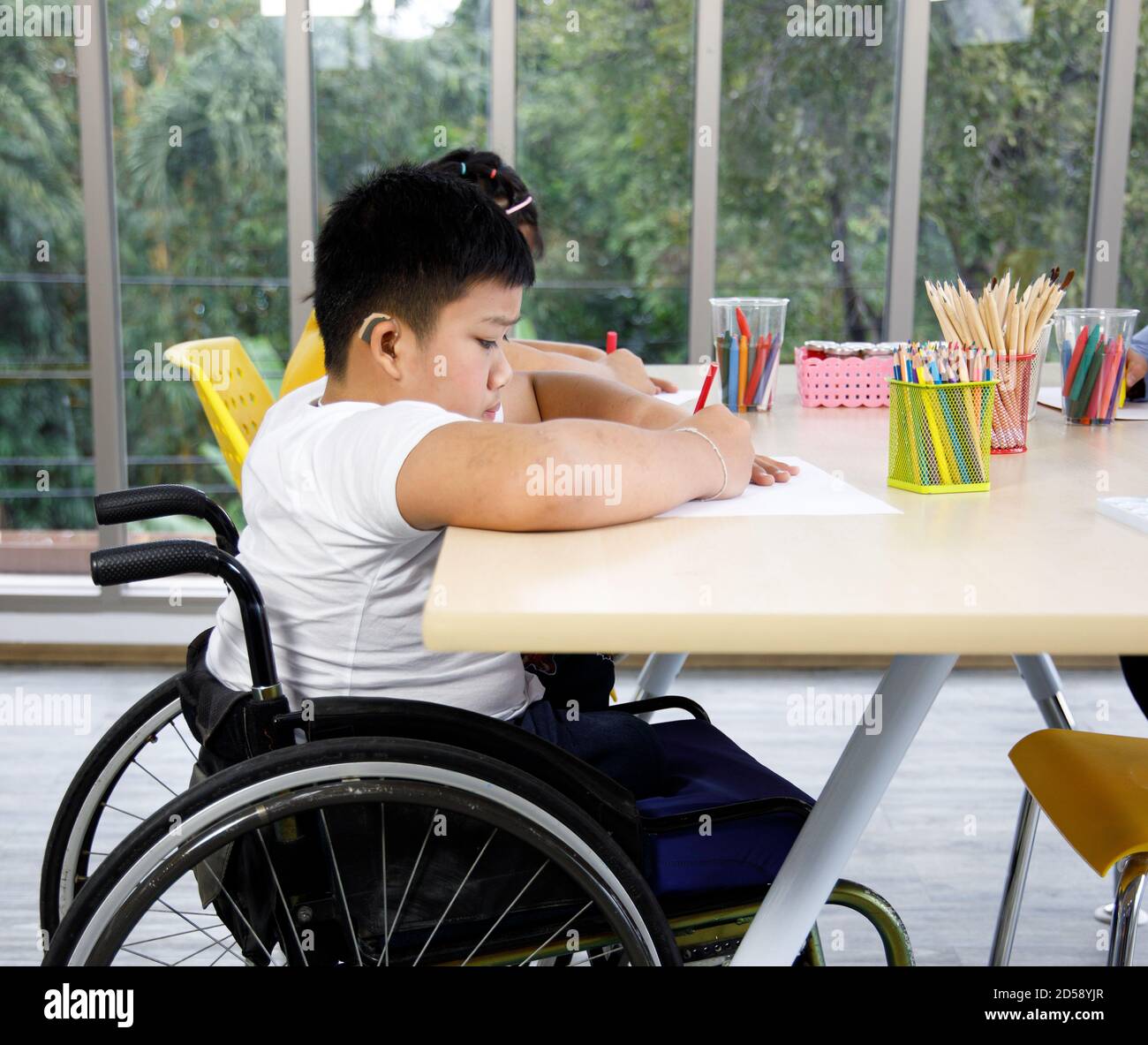 Bambino asiatico disabili su sedia a rotelle disegno immagine in classe d'arte. Foto Stock