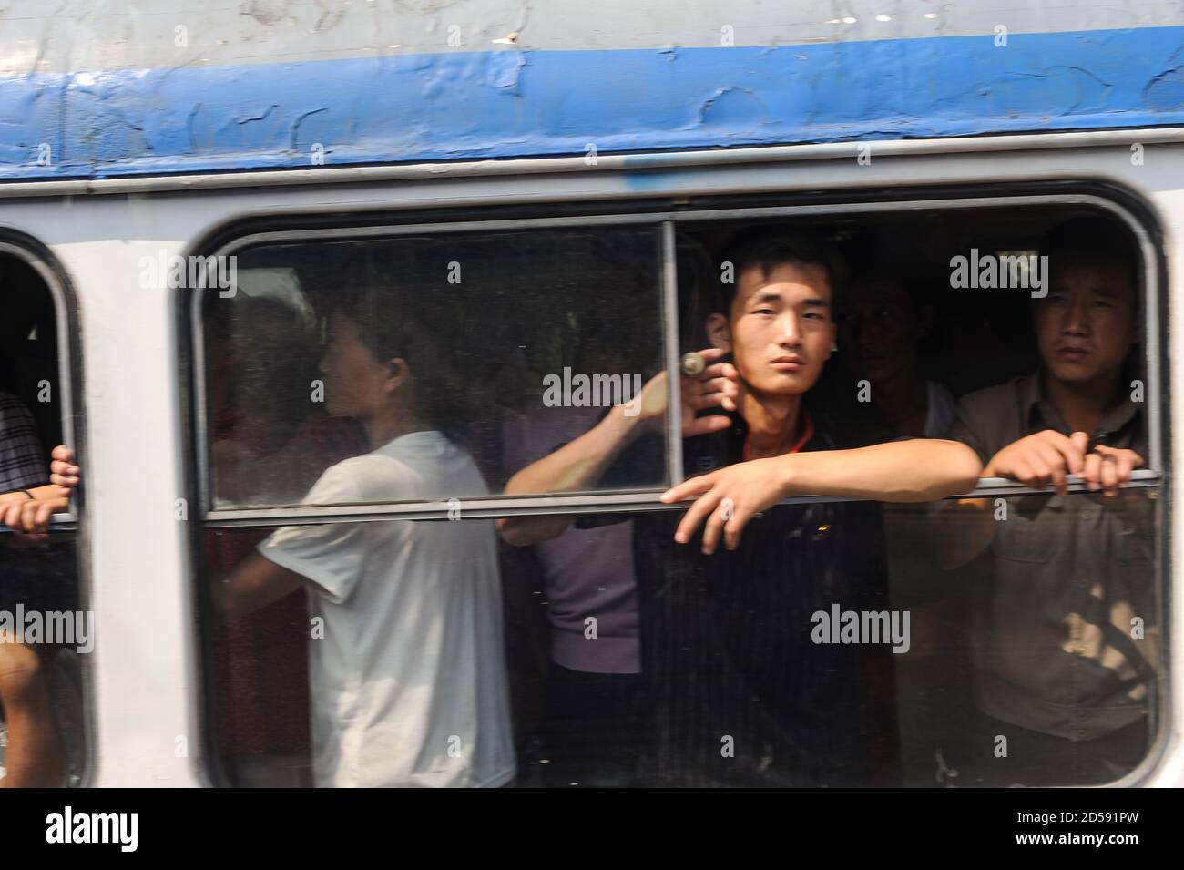 08.08.2012, Pyongyang, Corea del Nord, Asia - i pendolari guardano fuori dalla finestra aperta di un tram completamente occupato nel centro della capitale della Corea del Nord. Foto Stock