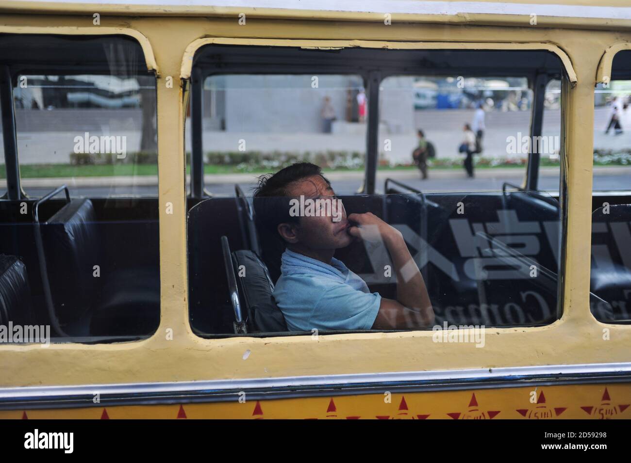 08.08.2012, Pyongyang, Corea del Nord, Asia - UN uomo si affaccia sulla finestra di un autobus pubblico che passa nel centro della capitale della Corea del Nord. Foto Stock