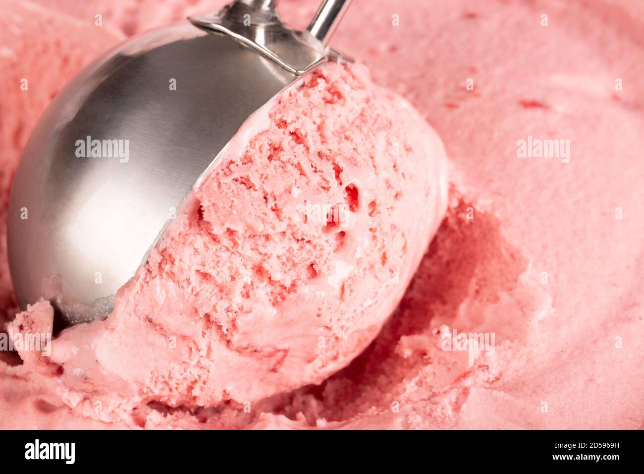 Primo piano di gelato alla fragola che viene ballato in su pronto a serv. Foto Stock
