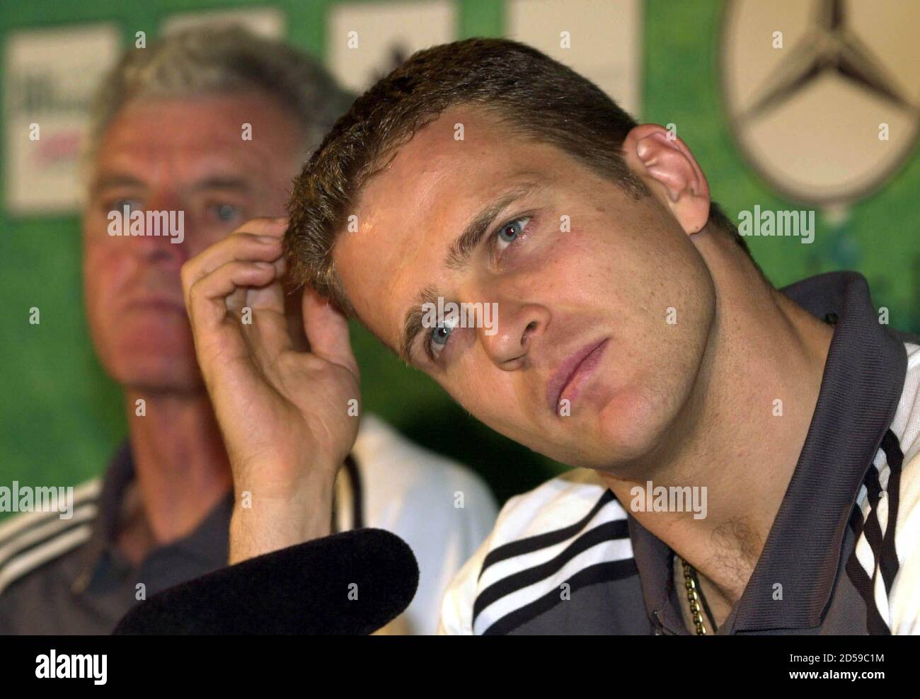 Oliver Bierhoff, capitano della squadra di calcio nazionale tedesca,  ascolta le domande mentre siede accanto al coach di squadra Erich Ribbeck  (L) durante una conferenza stampa a Zweibruecken, vicino a Homburg, aprile