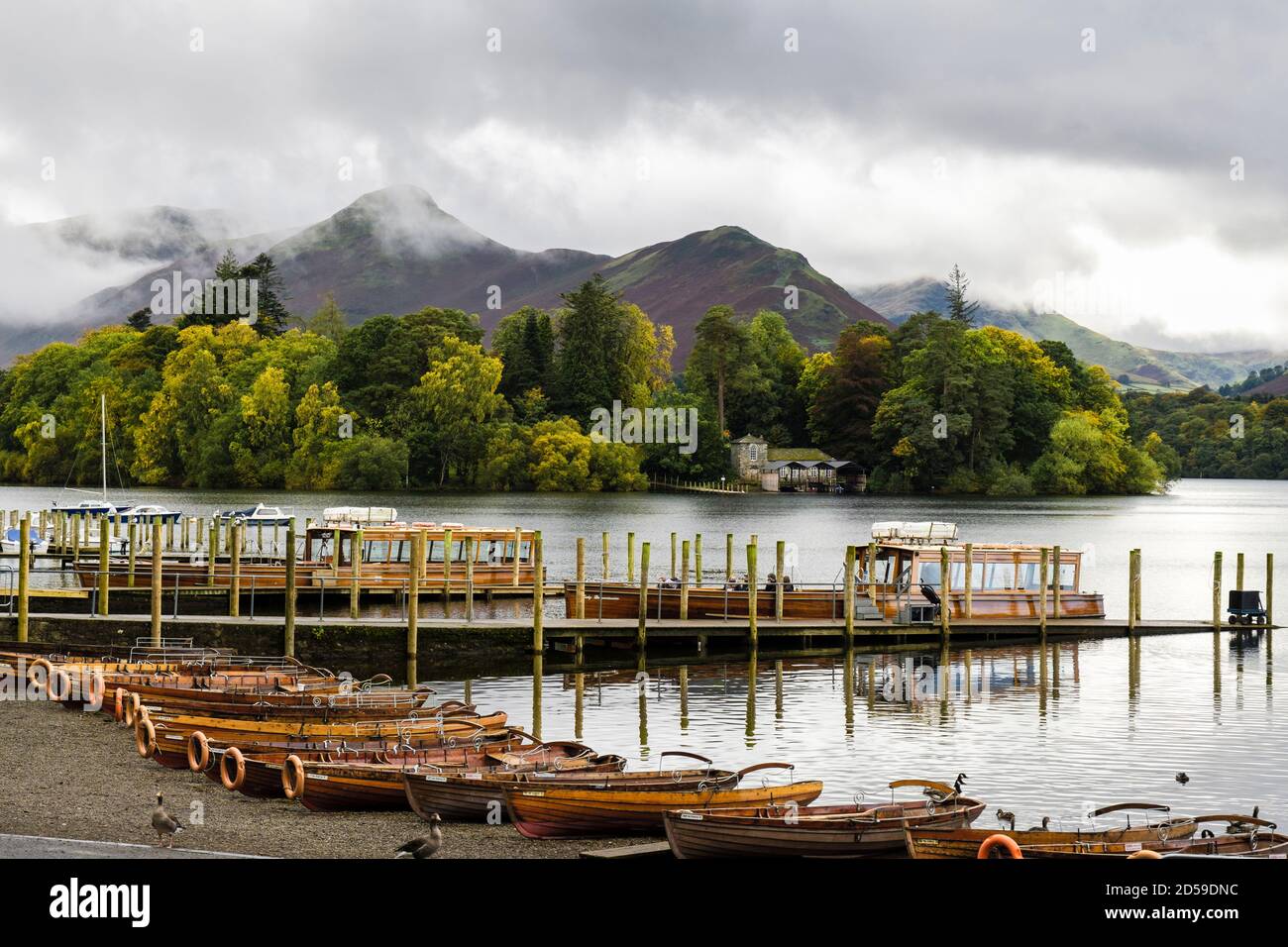 Barche a remi su Derwentwater con le tavole di atterraggio con Cat Bells Beyond Derwent Isle nel Lake District National Park in autunno. Keswick Cumbria Inghilterra Regno Unito Foto Stock