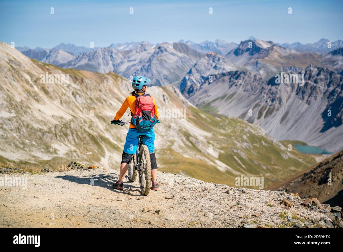 Vista posteriore di una donna su una mountain bike vista montagna, Arosa, Valle Schanfigg, Graubunden, Svizzera Foto Stock