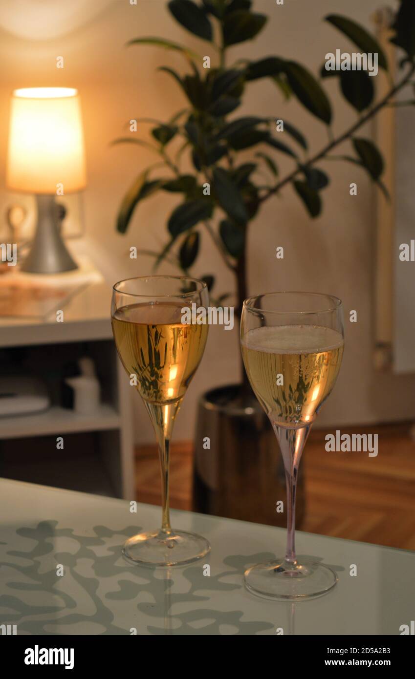 Due bicchieri di vino bianco sul tavolo, atmosfera romantica, casa accogliente decorazione durante le vacanze. Foto Stock