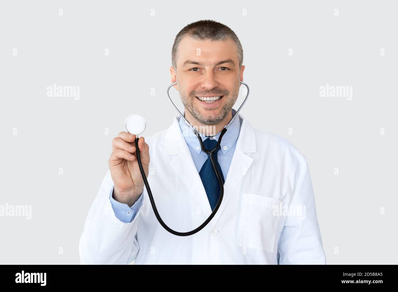 Ritratto di medico maturo sorridente e indicando lo spazio di copia Foto Stock