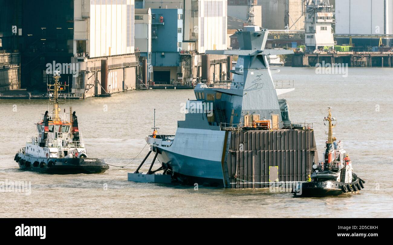 Amburgo, Germania. 13 ottobre 2020. Il piazzale della settima imbarcazione della classe corvette K130 (chiamata anche classe Braunschweig dopo il tipo di nave), costruita presso il cantiere navale Lürssen di Brema, sta navigando sull'Elba, movimentata da due rimorchiatori, in direzione del cantiere Blohm Voss. Credit: Markus Scholz/dpa/Alamy Live News Foto Stock