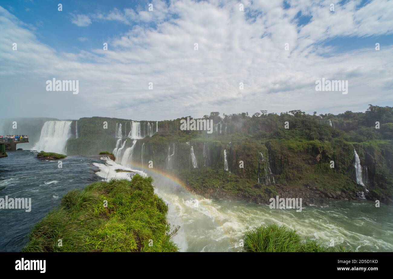 Vista panoramica sulle cascate di Iguazzu in brasile. Quando il sole si rompe attraverso la copertura nuvolosa, si formano arcobaleni nello spray. Foto Stock