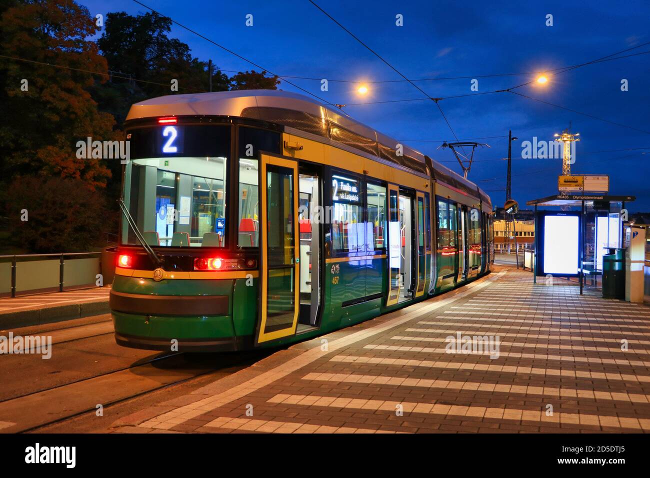 HSL tram n° 2 alla fermata del tram la mattina prima dell'alba, con luci di strada che illuminano la vista della città. Helsinki, Finlandia. 29 settembre 2020. Foto Stock