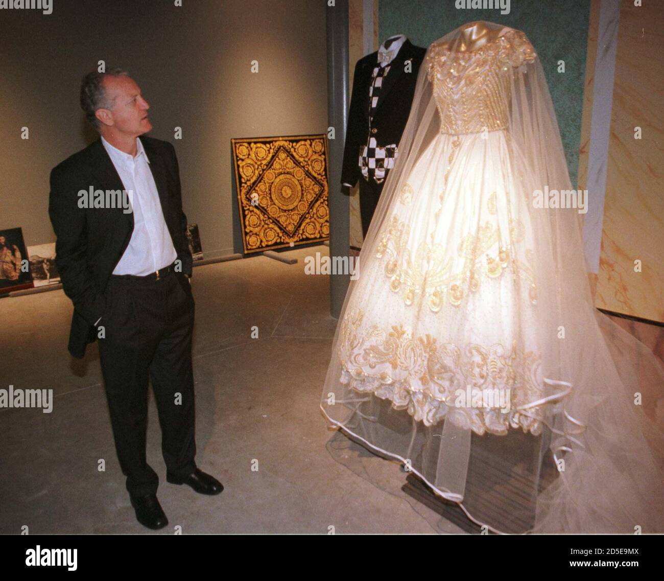 Santo Versace guarda un cappotto di coda nero e un abito, progettato dal  suo fratello Gianni Versace e indossato dal musicista Sting e Trudie Styler  al loro matrimonio nei primi anni '80