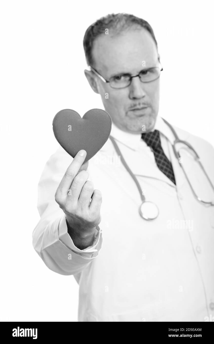 Studio di un medico uomo maturo che tiene il cuore con fuoco a cuore Foto Stock