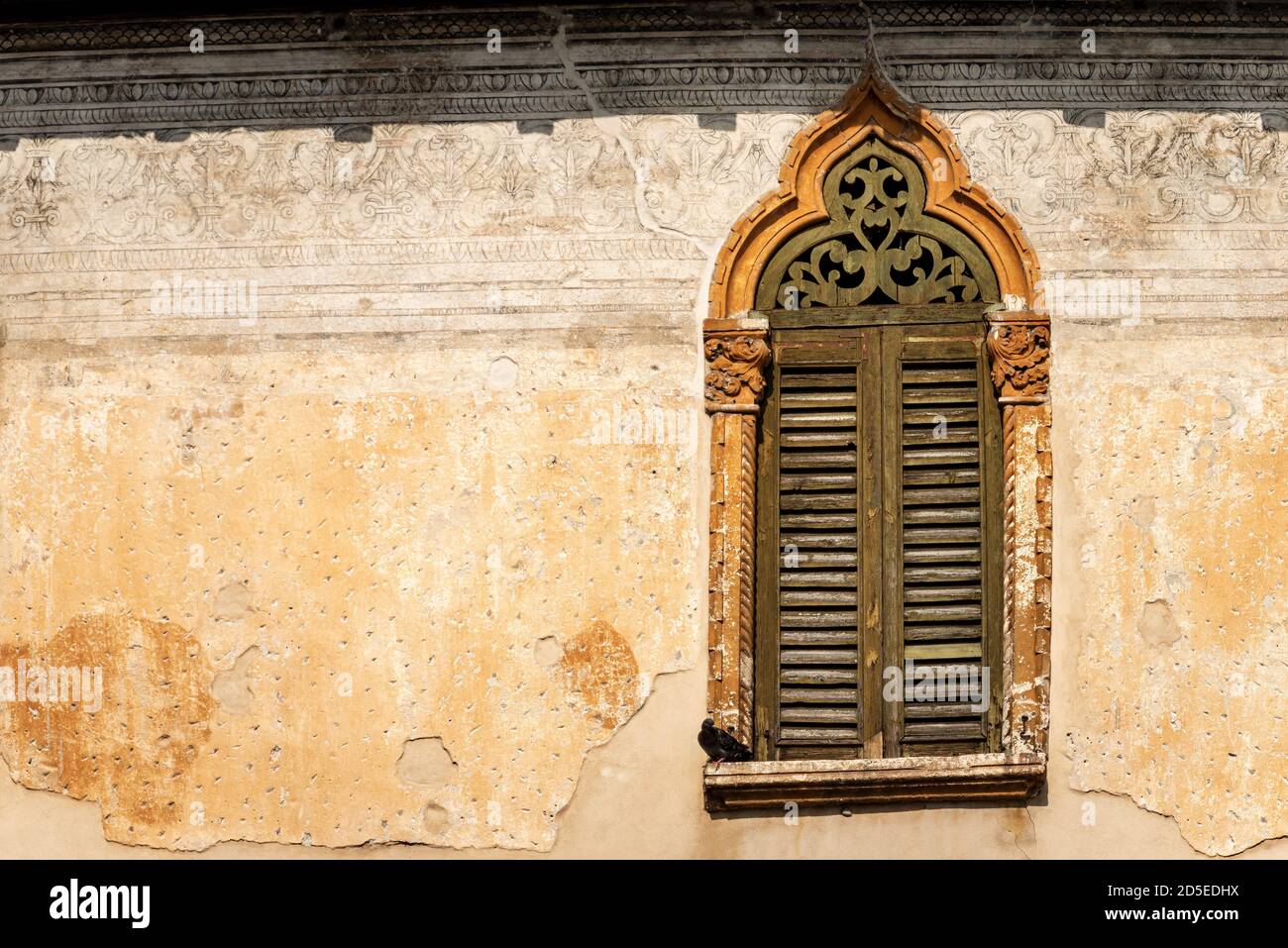 Primo piano di un'antica finestra con arco in stile gotico veneziano, nel centro di Verona. Patrimonio dell'umanità dell'UNESCO, Veneto, Italia, Europa. Foto Stock