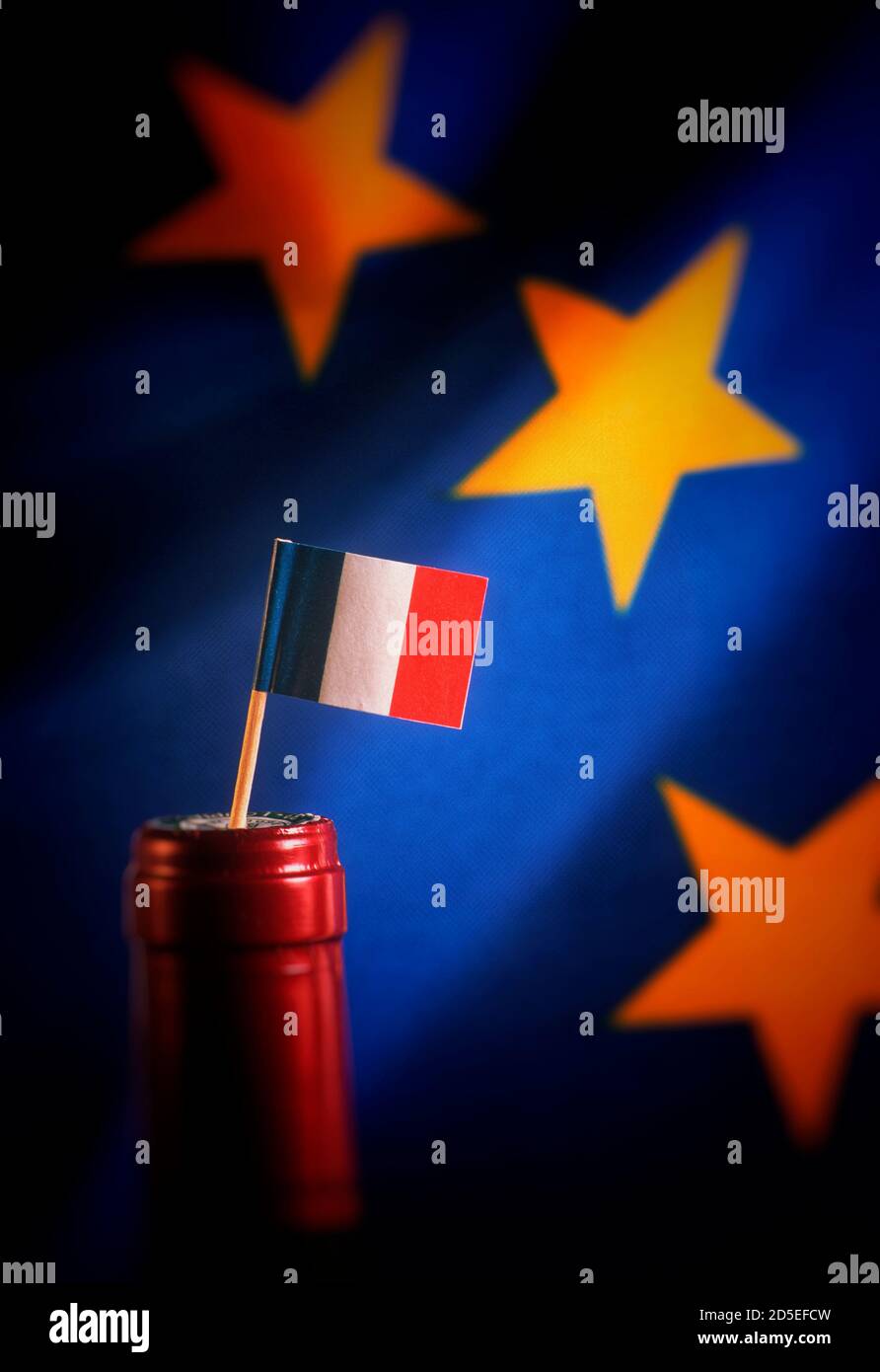 Unità europea con bandiera francese in cima a una bottiglia di vino sullo sfondo blu con stelle Foto Stock