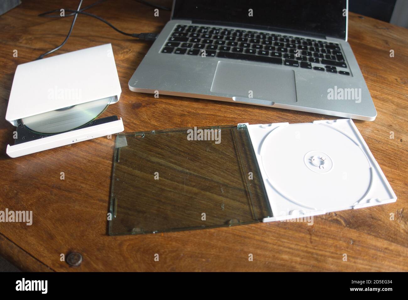 Un lettore/masterizzatore CD/DVD esterno collegato a un computer portatile tramite USB - utilizzato per leggere o scrivere su CD e DVD. Foto Stock
