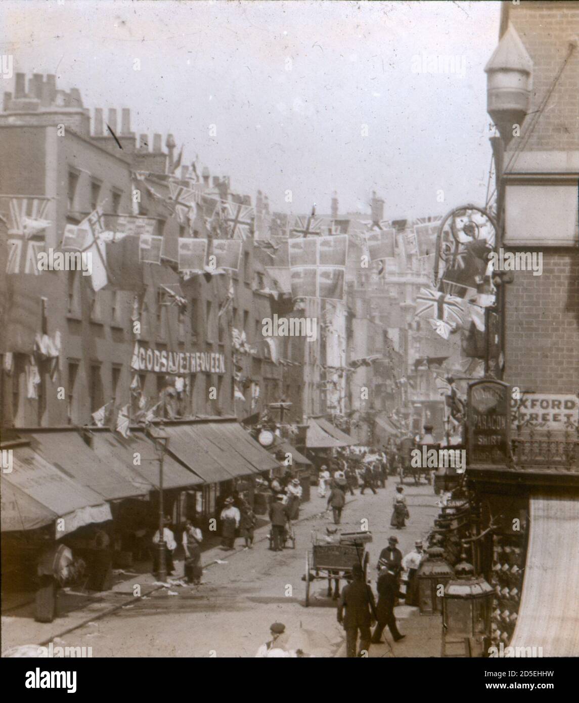 La gente vittoriana viaggia intorno e fa il loro shopping a Londra del diciannovesimo secolo, all'incrocio di St James Street e Oxford Street. Sono visibili le bandiere e i conigli che celebrano l'ottantesimo compleanno della Regina Vittoria. Foto Stock