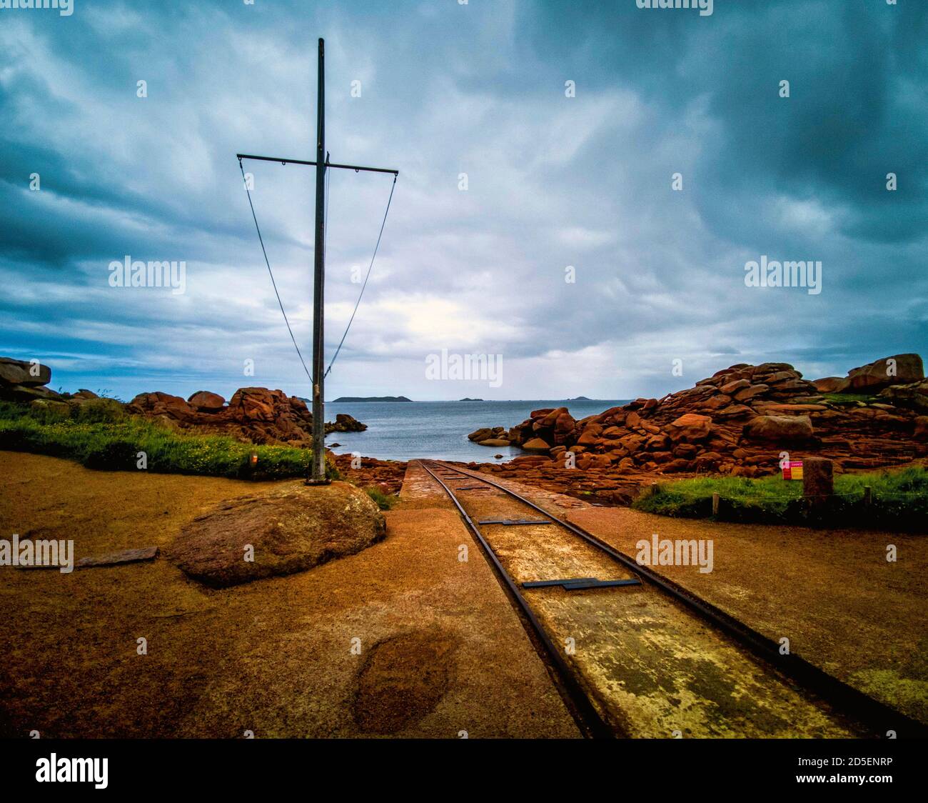 Le vie conducono giù al mare presso la stazione di salvataggio al francese Breton porto di pesca di Ploumanach. Bretagne. Francia Foto Stock