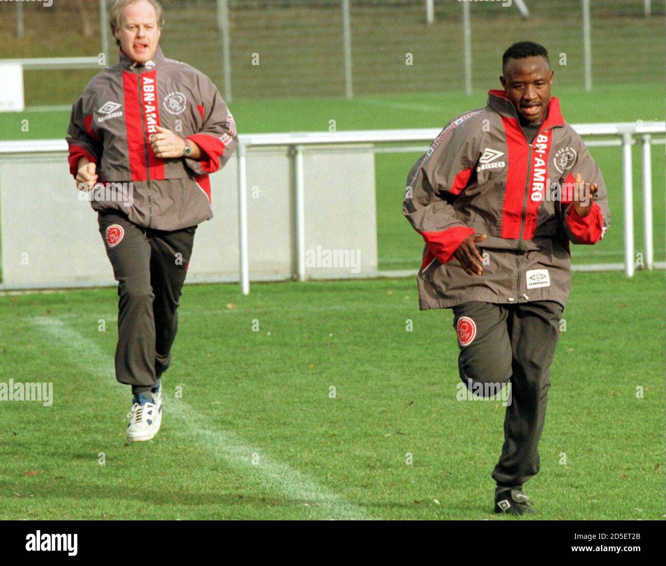 Il giocatore di calcio Babangiga della squadra di calcio olandese Ajax  Amsterdam (R) è accompagnato da un assistente allenatore durante una  sessione di allenamento a Zurigo il 3 dicembre. AJAX affronterà Grasshoppers