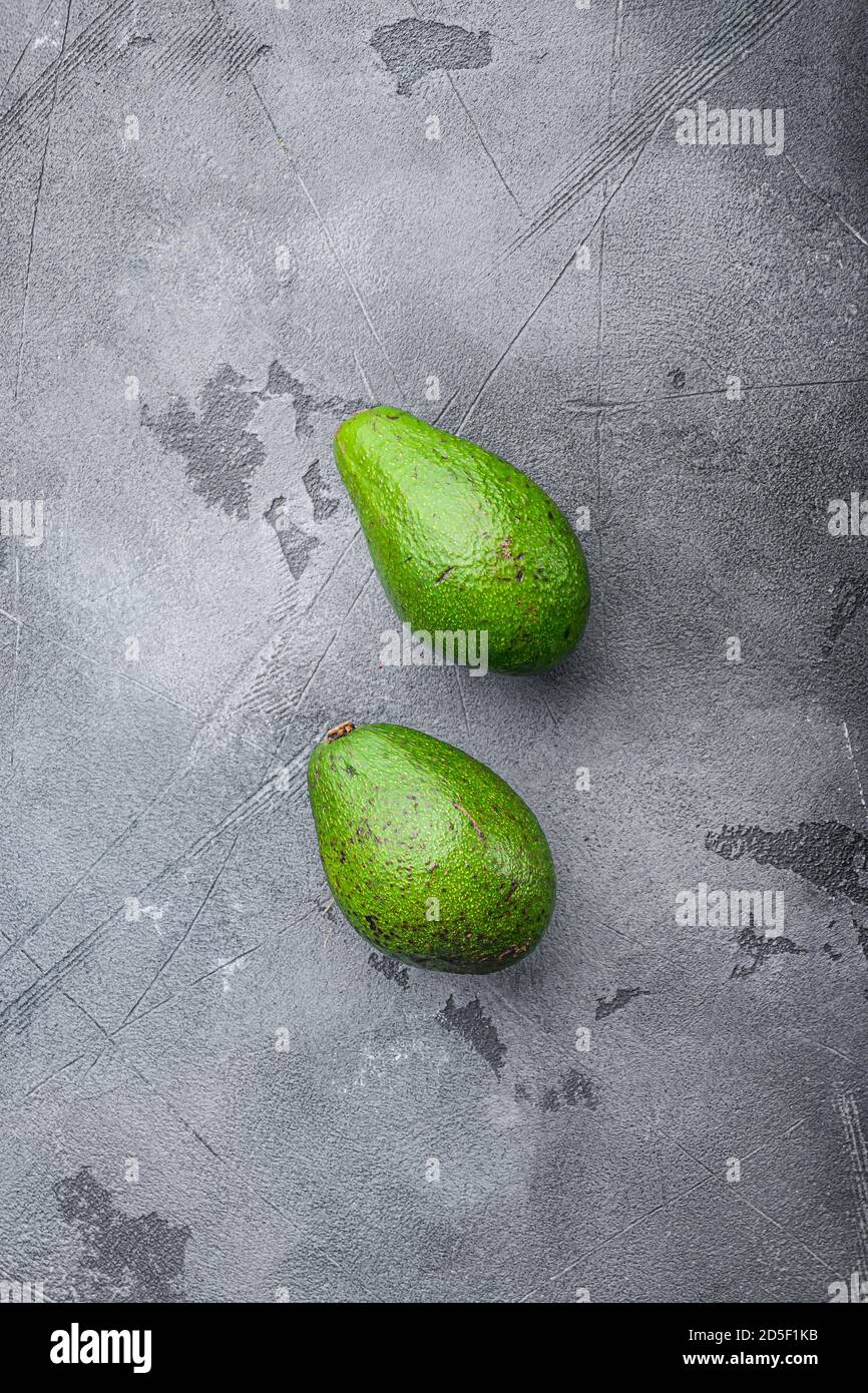 Avocado organico su sfondo grigio testurizzato, vista dall'alto. Foto Stock