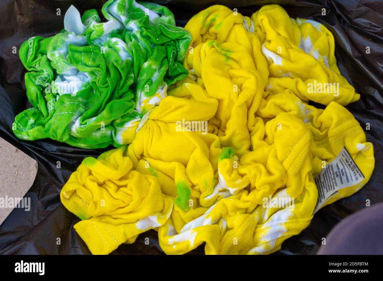Maglietta color giallo e verde con tintura bagnata per i concetti creativi e artistici dei bambini. Foto Stock