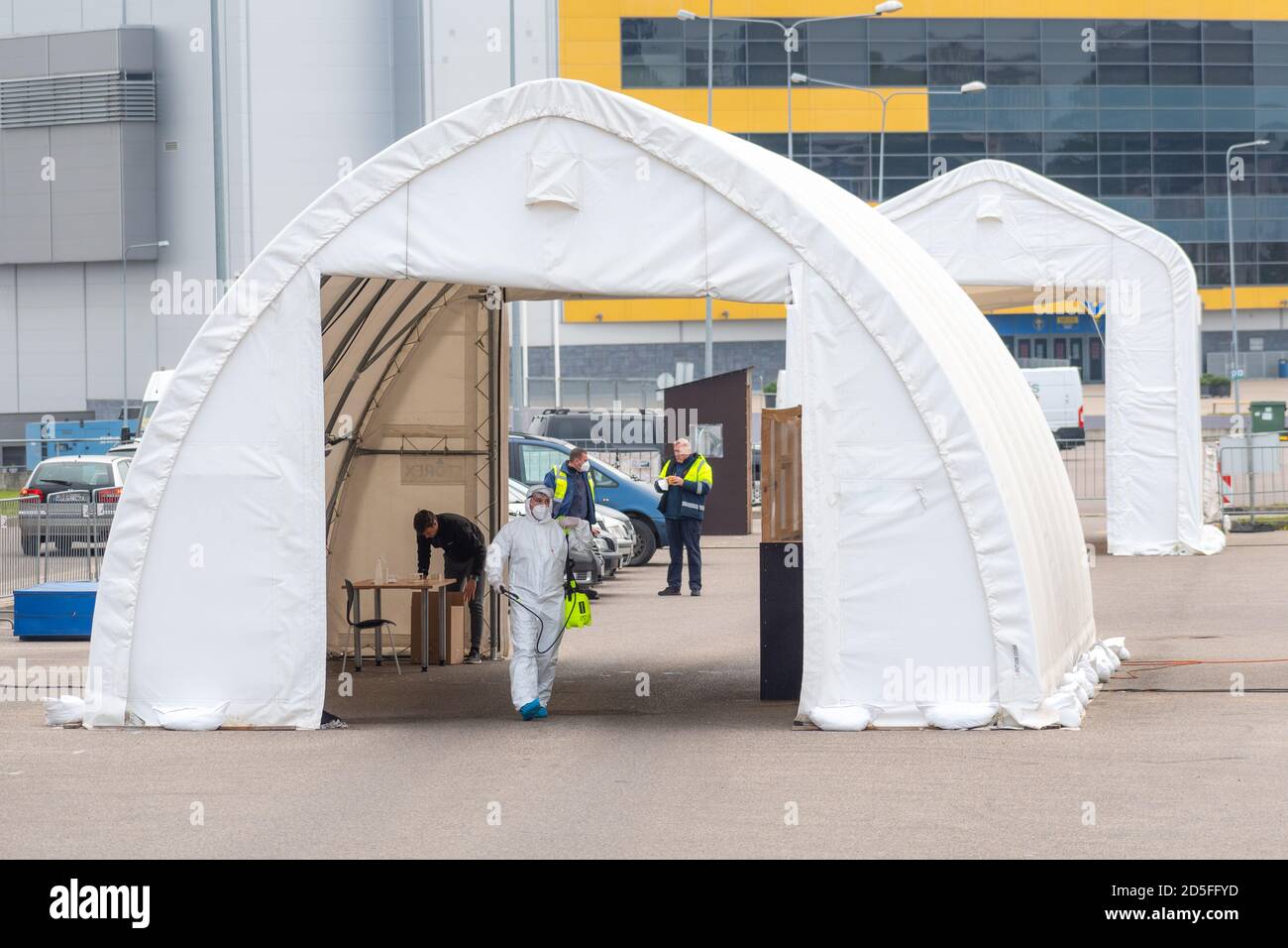Paramedico indossare dispositivi di protezione disinfezione stazione di test mobile tenda per auto durante Coronavirus o COVID19 focolaio, hotspot medico Foto Stock