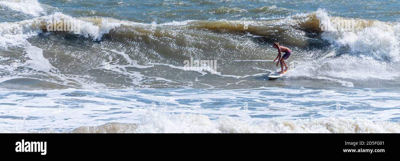 La combinazione di una nor'easter e dell'uragano Teddy ha prodotto onde aeree per avventurosi surfisti ai Poles a Jacksonville, Florida. Foto Stock