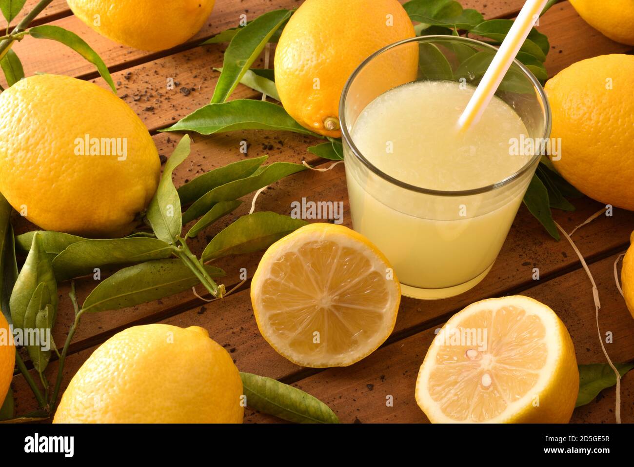 Spremuta fresca su un tavolo di legno su un vassoio pieno di limoni. Vista rialzata. Composizione orizzontale. Foto Stock