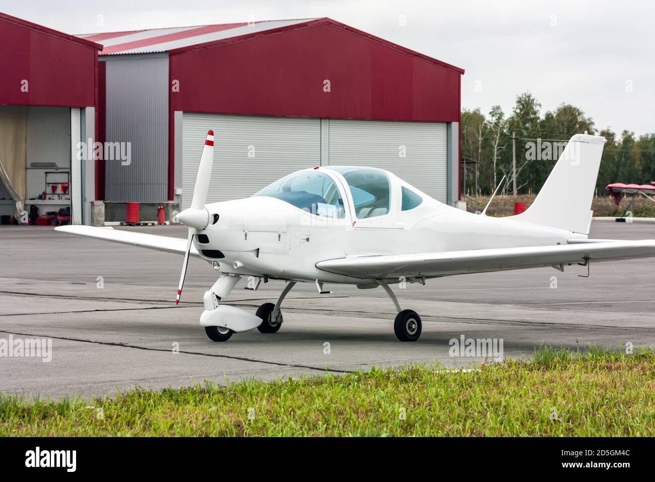 Un aereo sportivo accanto agli hangar Foto Stock