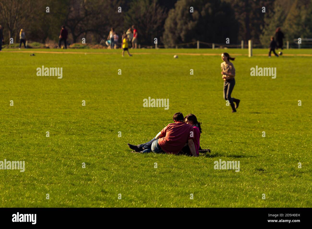 Oxford, UK 03/19/2011: Una giovane coppia caucasica sta avendo un po' di tempo libero mentre si siedono sull'erba e si rilassano nel parco universitario di Oxford Univer Foto Stock