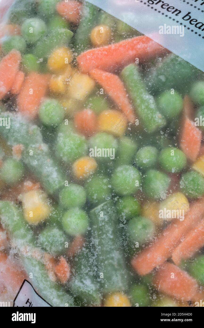 Primo piano di un sacchetto di plastica di scongelamento di verdure miste surgelate (mettere a fuoco sui cristalli di ghiaccio sul sacchetto). Per il confezionamento di alimenti in plastica, ingredienti da cucina. Foto Stock