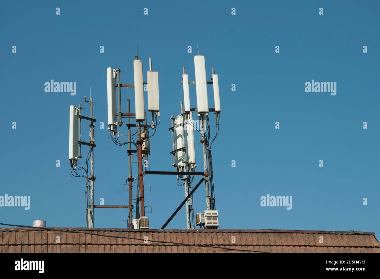 Il cellulare antenna di comunicazione sulla copertura di un edificio Foto Stock