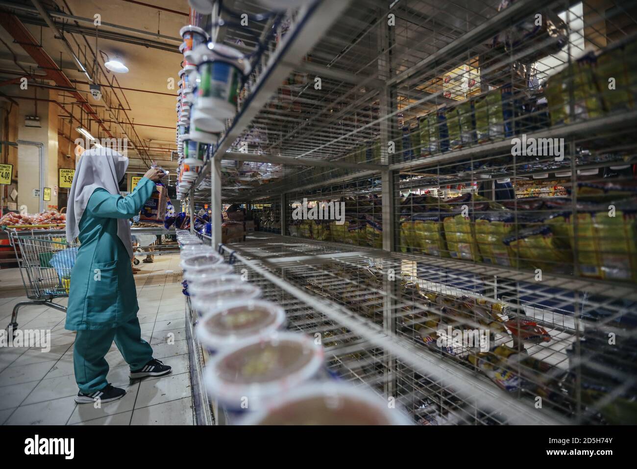 Una donna che fa acquisti in un supermercato a seguito di un CMCO (Conditional Movement Control Order) reimposto dal governo malese per due settimane quando i casi si impiccano tra le preoccupazioni del coronavirus (Covid-19). Foto Stock