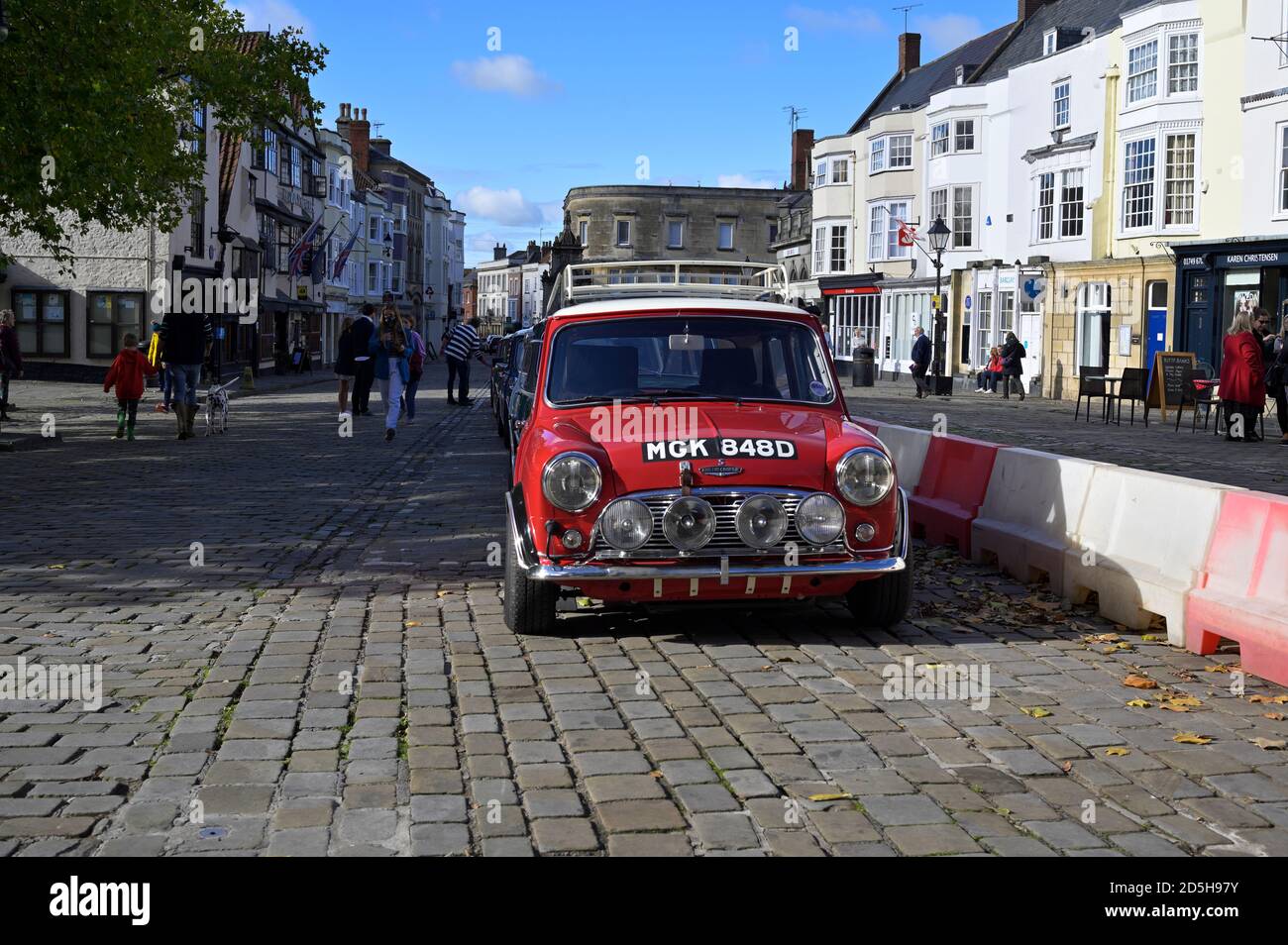 Una vista frontale di un motore doppio 1965 Austin Mini Copper S con altri minis parcheggiati presso la piazza del mercato di Wells Foto Stock