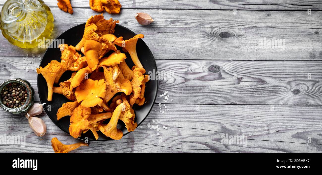 Vista dall'alto di un piatto con funghi chanterelles freschi sfondo grigio rustico Foto Stock