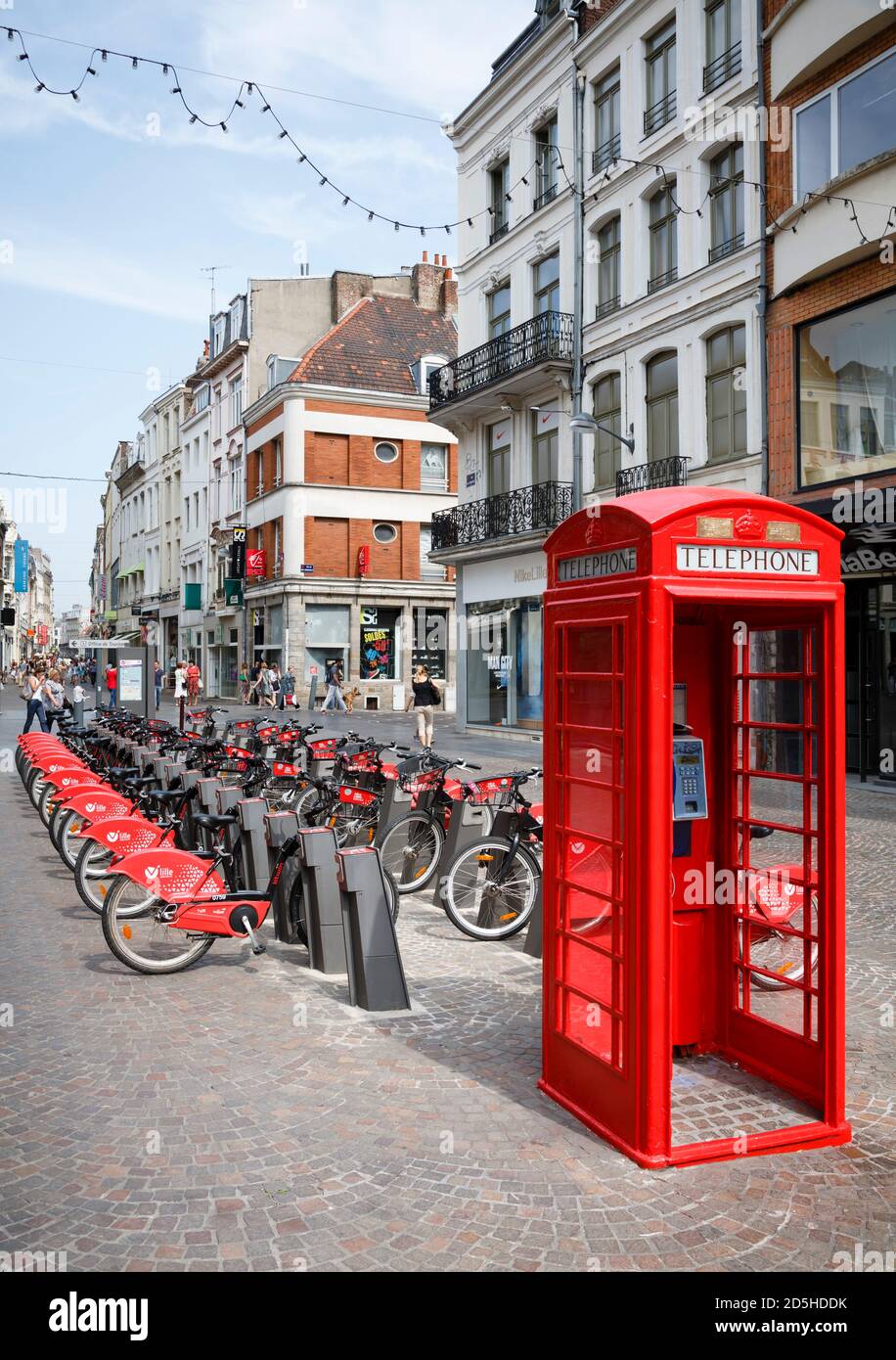 LILLE, FRANCIA - 18 luglio 2013. Noleggio biciclette gratuito stazione e telefono rosso britannico in una strada a Lille, Francia Foto Stock