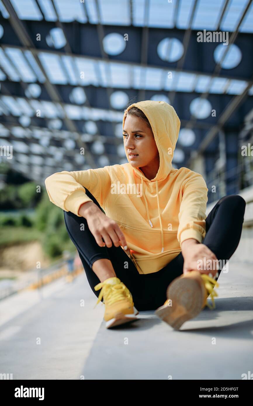 Donna attiva in abbigliamento sportivo riposante durante la giornata di sole Foto Stock